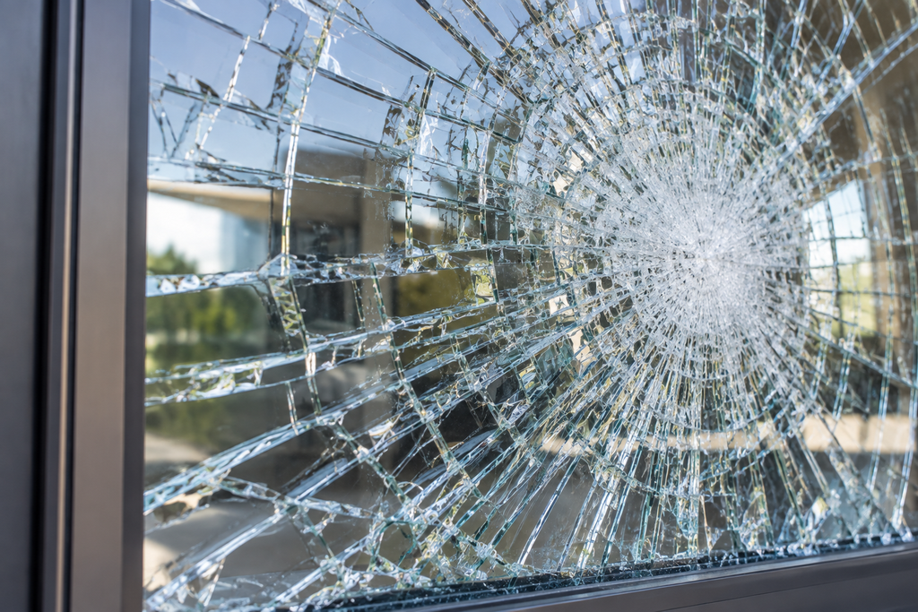 Security film holding cracked glass together after impact to reduce loose fragments